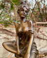 Статуя женщины на стуле из бронзы