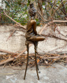 Статуя женщины на стуле из бронзы