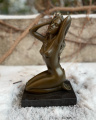 Статуя обнаженной сидящей девушки из бронзы