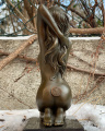 Статуя обнаженной сидящей девушки из бронзы