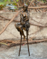 Статуя девушки на стуле из бронзы