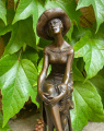 Статуя женщины со шляпой на стуле из бронзы