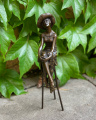 Статуя женщины со шляпой на стуле из бронзы